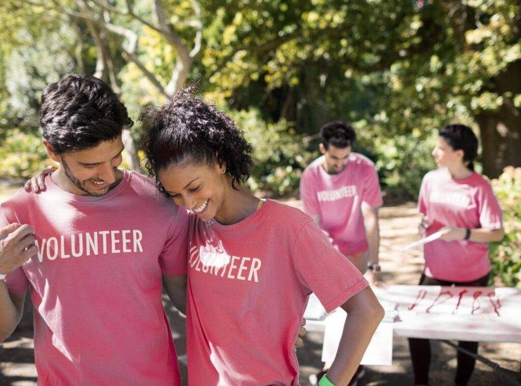A collection of colorful volunteer t-shirts displayed on a table